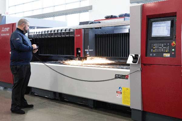 worker operating a fiber laser cutter